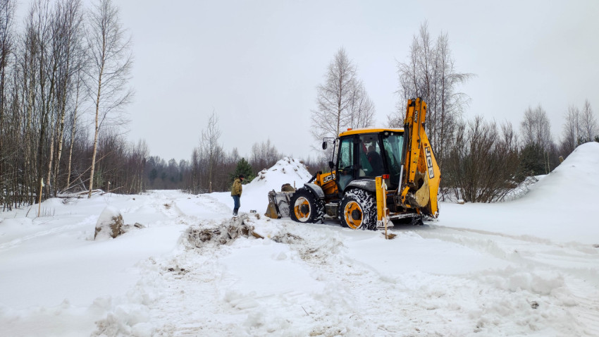 Экскаватор-погрузчик JCB на заснеженной стройплощадке