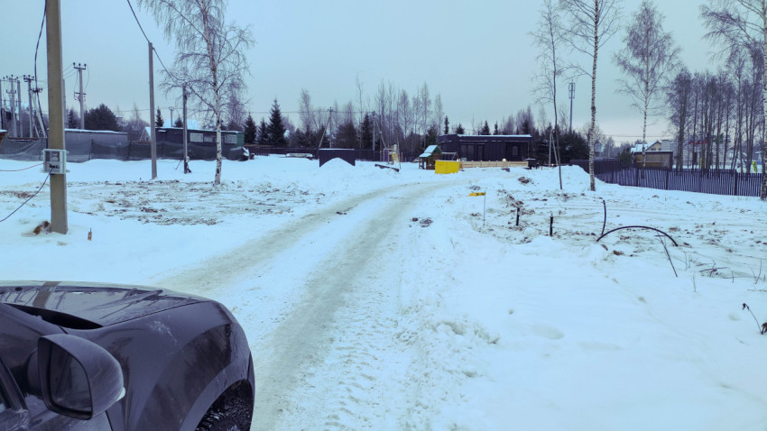 Заснеженная дорога на территории загородного поселка
