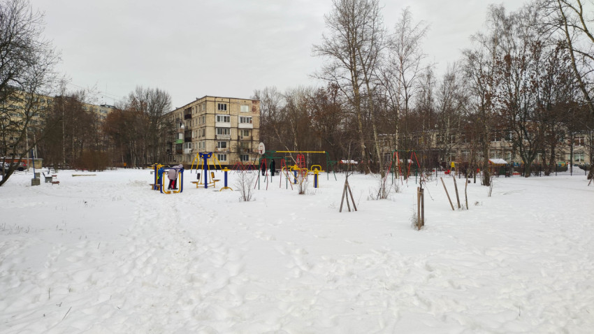 Зимний вид на детскую и спортивную площадку в жилом районе города