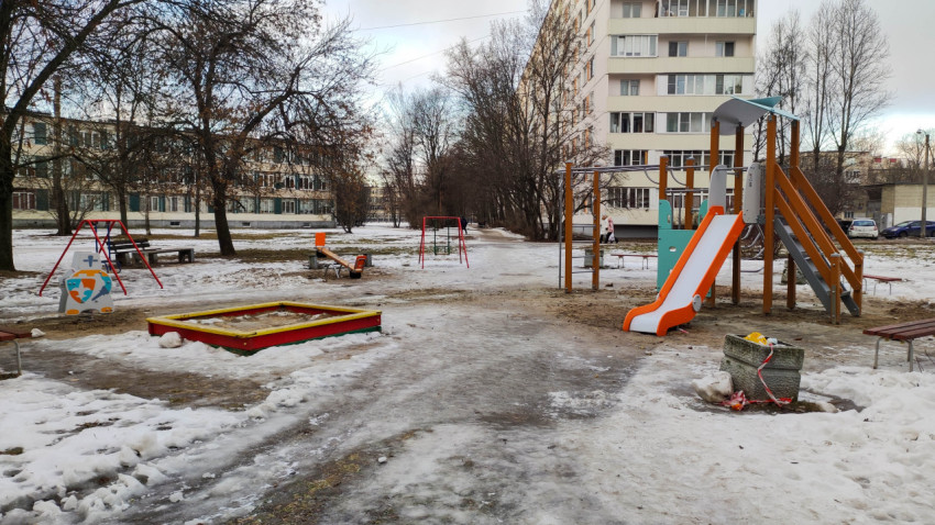 Детская площадка во дворе жилого дома в зимний период