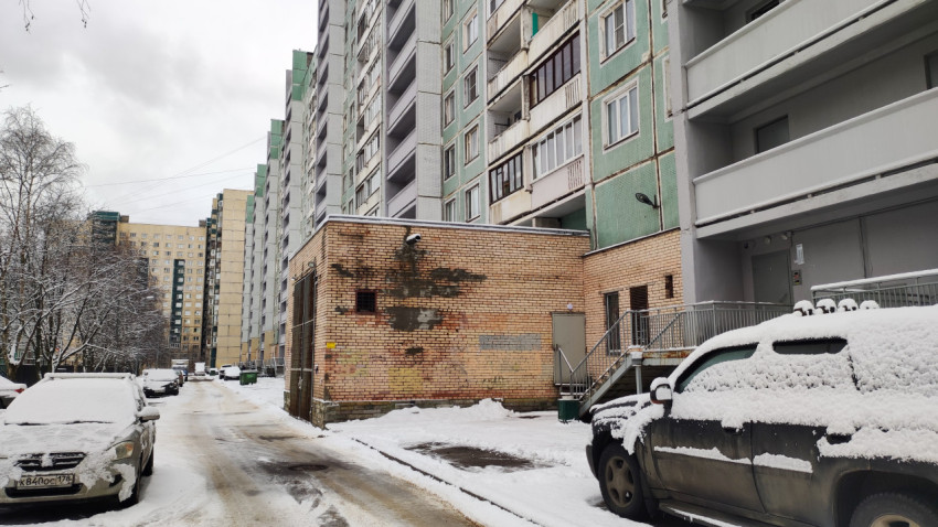 Дворовая часть жилого дома с припаркованными автомобилями зимой