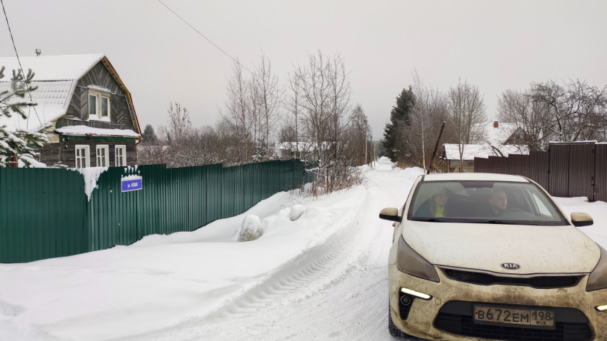Деревенская улица с табличкой "ул. Новая" и проезжающим автомобилем