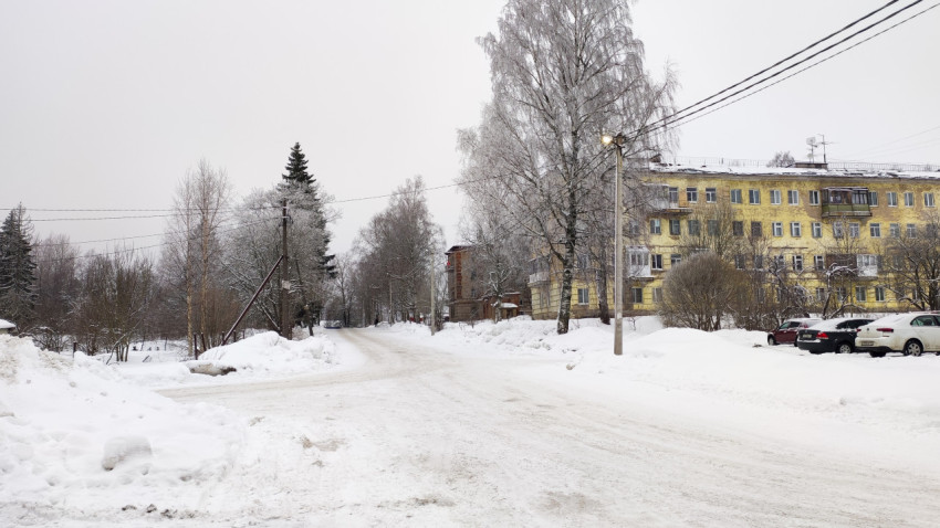 Жёлтое здание и освещённая улица в зимнем городском квартале