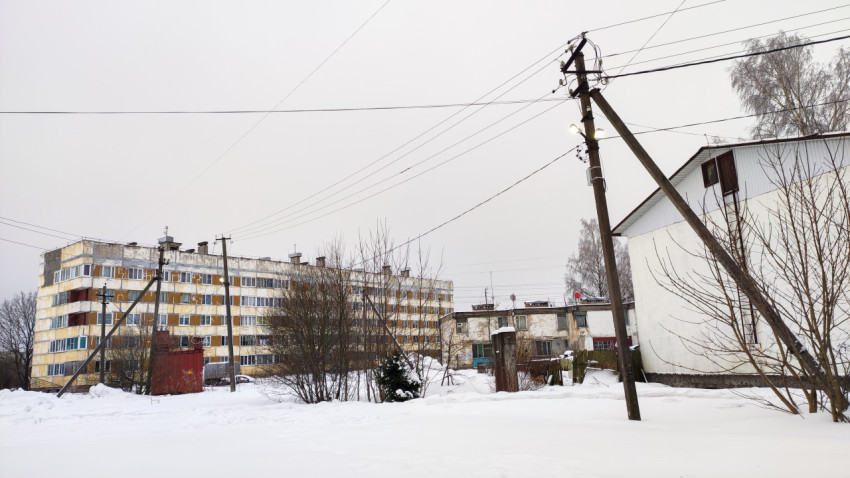 Жилой район зимой: панельный дом и линии электропередач