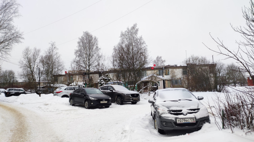 Жилой двор зимой с автомобилями и фасадами старых двухэтажных домов