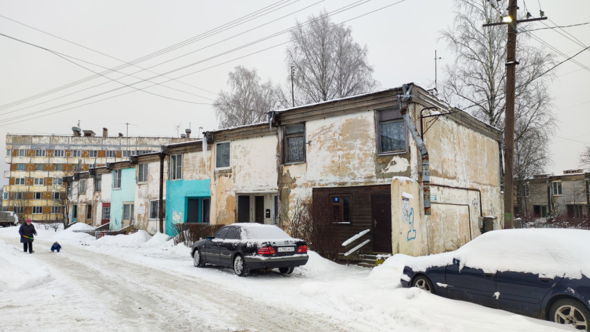 Жилые дома с облупившимися фасадами и припаркованными машинами