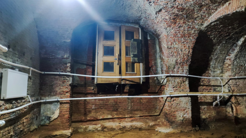 Деревянные двери в кирпичной стене исторического подвала