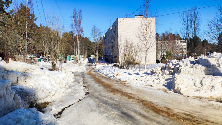 Снег и лёд на дворовой дороге между многоквартирными домами