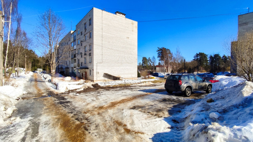 Зимняя парковка у торца жилого дома с автомобилями