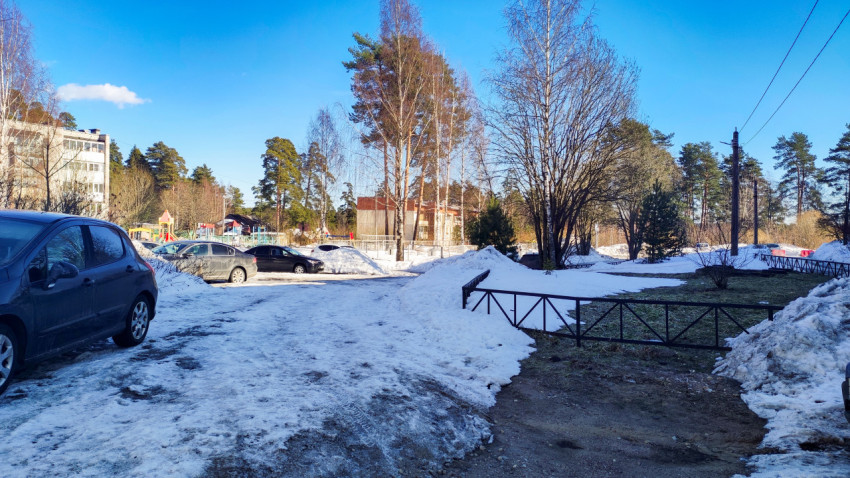 Парковка у детской площадки в заснеженном дворе