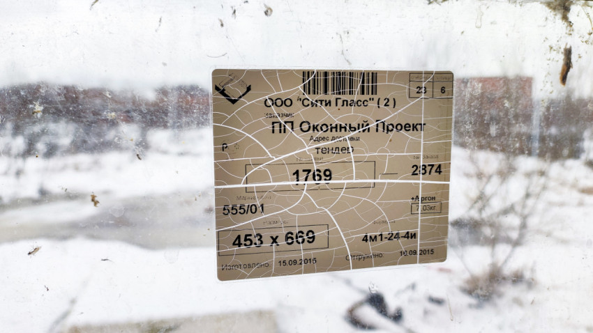 Этикетка стеклопакета на окне с зимним фоном