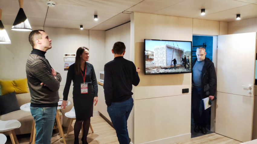 Посетители осматривают интерьер модульного дома Aira Homes