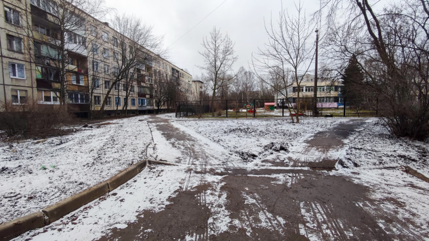 Заснеженный двор с тротуарами между жилыми домами