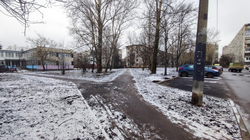 Пешеходные дорожки во дворе зимой рядом с парковкой