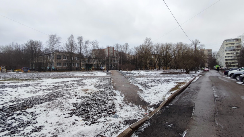 Пешеходная дорожка через заснеженный пустырь во дворе