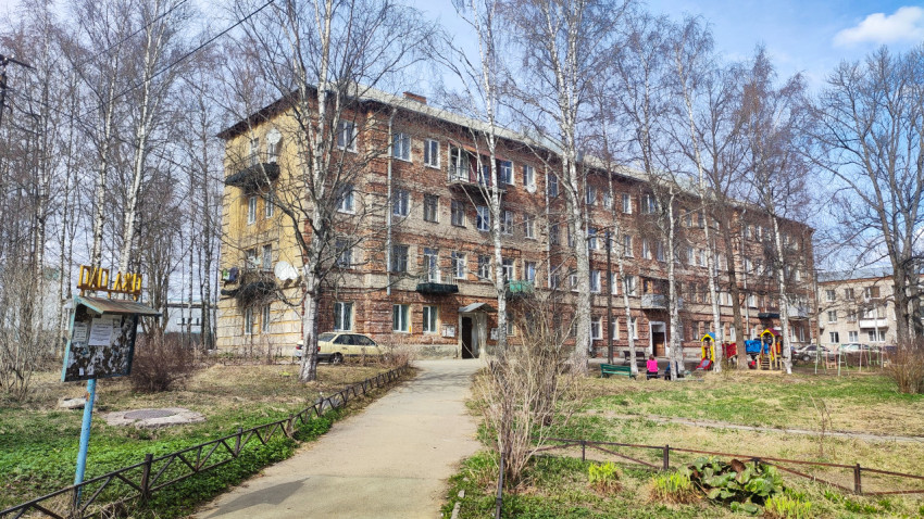 Жилой дом с кирпичным фасадом и детской площадкой во дворе