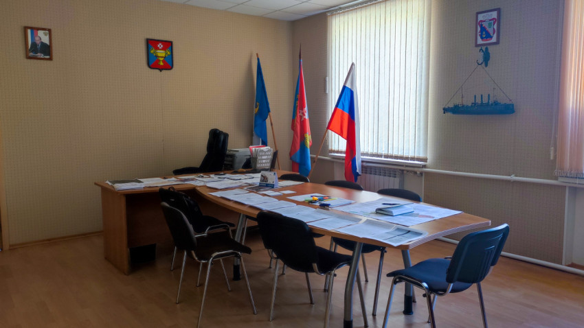 Кабинет с документами, флагами и гербами на стене