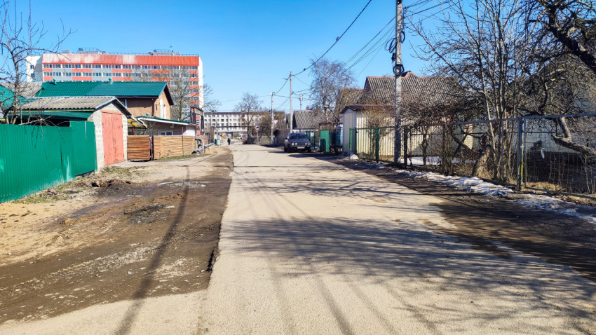 Асфальтированная улица в частном секторе с жилыми домами