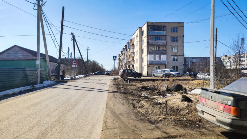 Многоквартирный дом у поворота с дорожными знаками