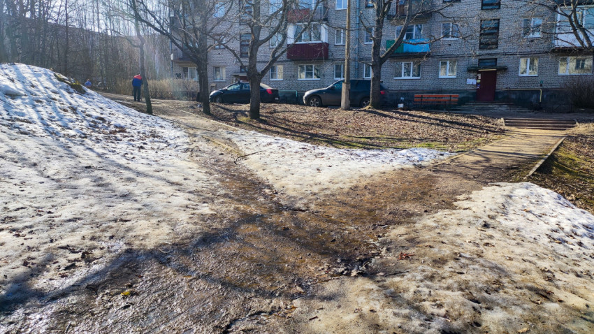 Талая вода на тротуаре у многоквартирного дома