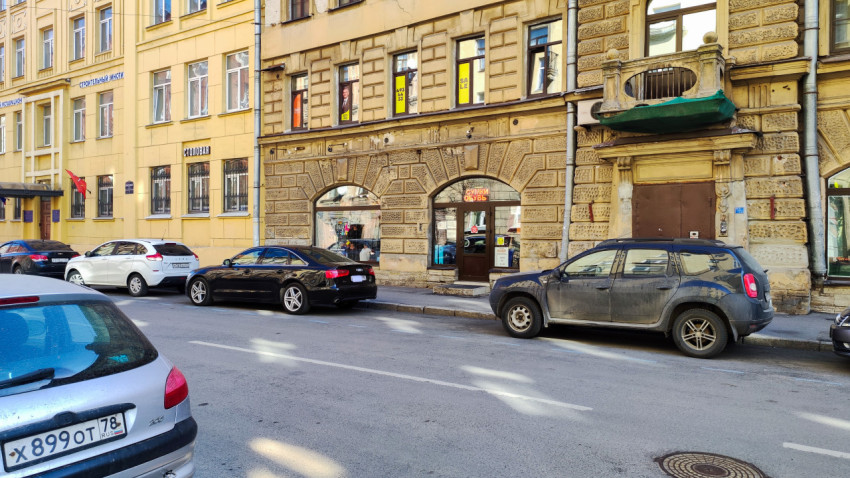 Фасады жилых зданий и припаркованные автомобили в центре города