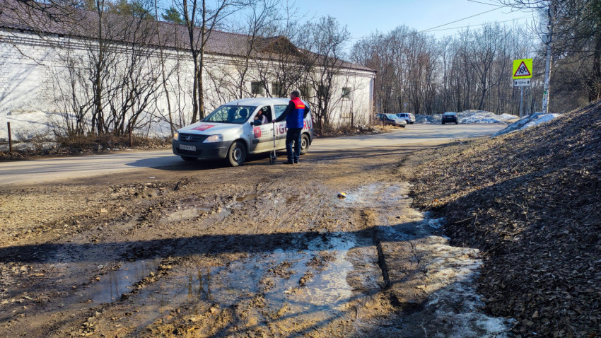 Мужчина у автомобиля с логотипом службы доставки