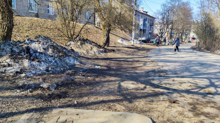 Грязные снежные кучи на обочине дороги в жилом районе