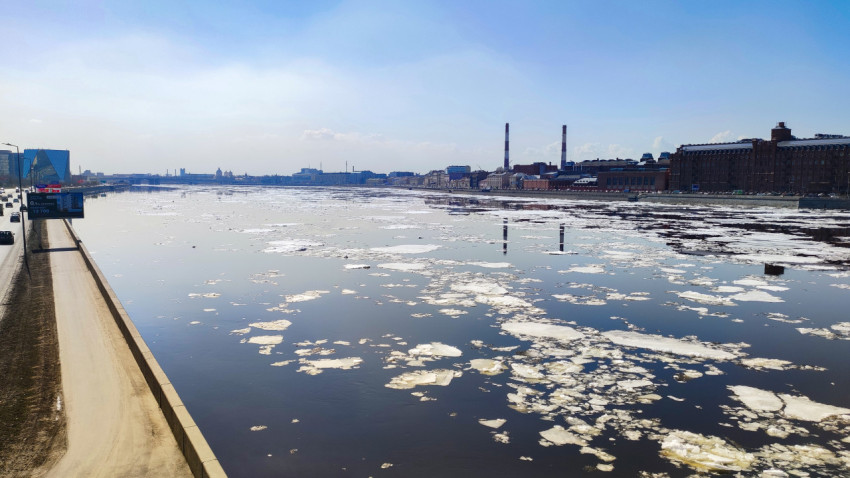 Панорама Невы с плавающими льдинами и видом на городские здания и трубы