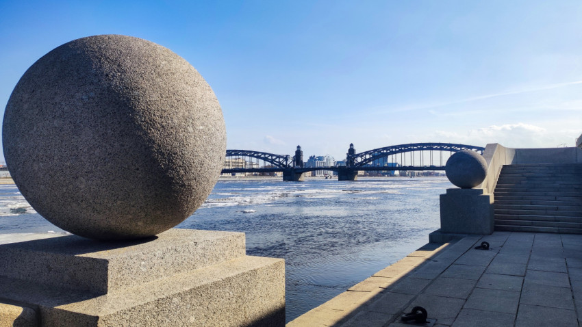 Гранитная набережная, шары и мост через Неву в весенний день