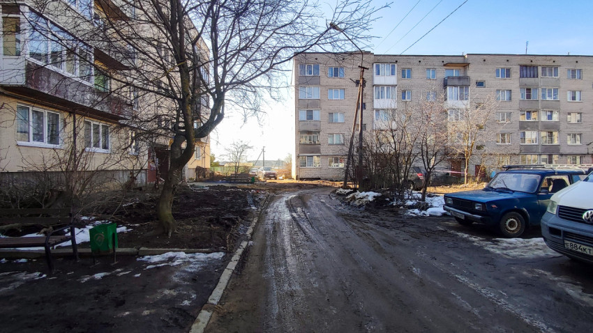 Двор между многоквартирными домами с грязной дорогой