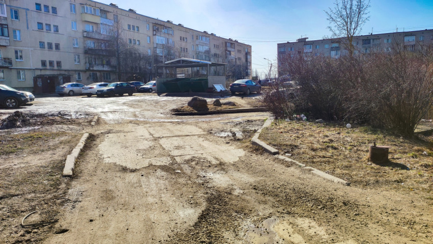 Двор жилого квартала с мусорной площадкой и припаркованными машинами