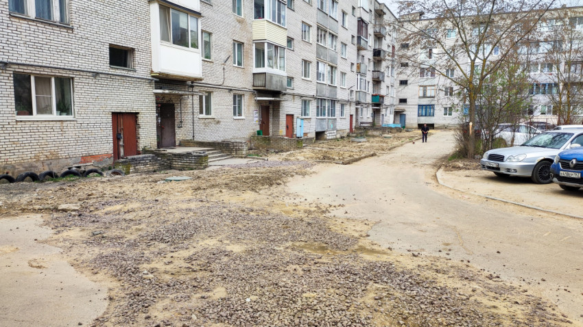 Фасад жилого дома и двор с незавершёнными дорожными работами