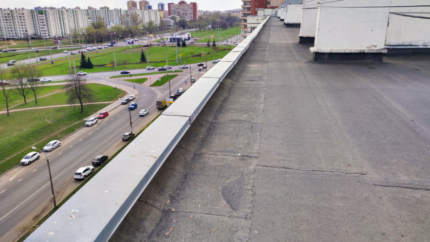 Кровля многоквартирного дома и вид на дорогу с движением автомобилей