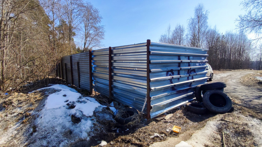 Склад покрышек у металлического забора зимой