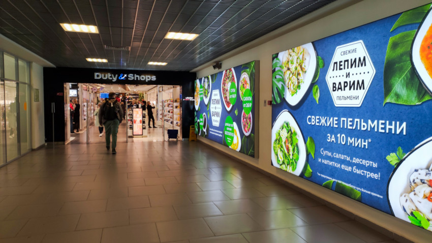 Торговая зона с магазином Duty Free и рекламой кафе