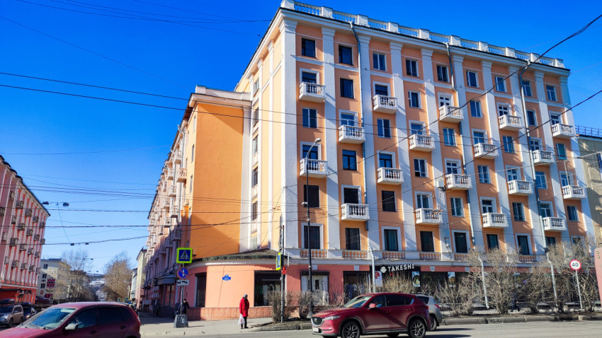 Фасад капитанского дома №72 на проспекте Ленина в Мурманске с городской улицей