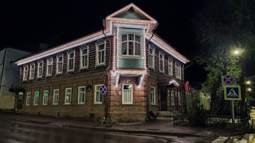 Двухэтажный деревянный дом с подсветкой фасада ночью