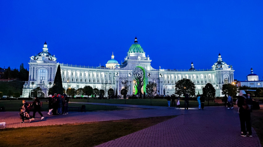 Казанский дворец земледельцев в вечернем освещении с людьми