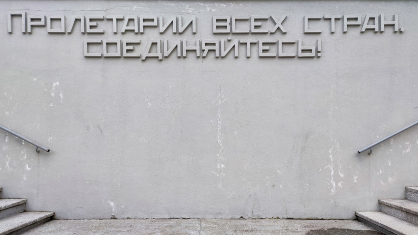 Надпись Пролетарии всех стран соединяйтесь на бетонной стене