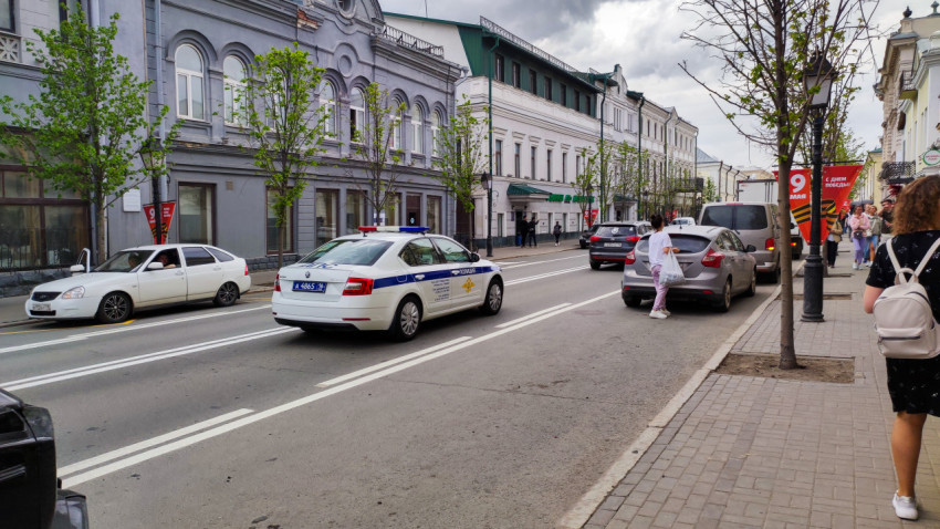 Полицейская машина на улице города в дневное время