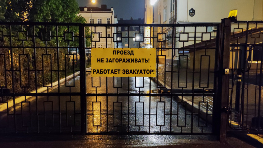 Ворота с предупреждающей табличкой о работе эвакуатора