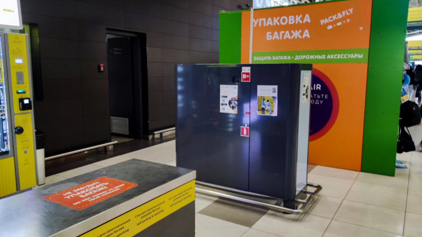 Станция упаковки багажа и автоматы в терминале аэропорта