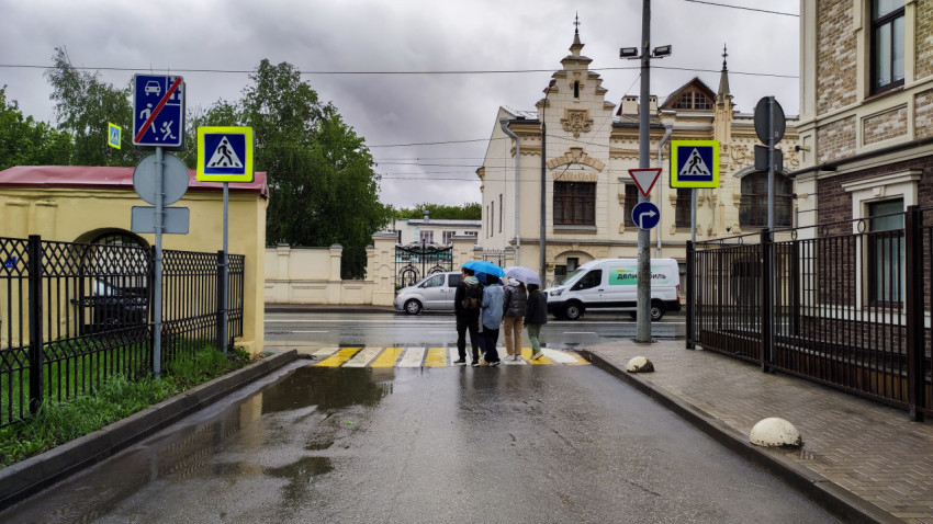 Группа людей на пешеходном переходе в дождливую погоду