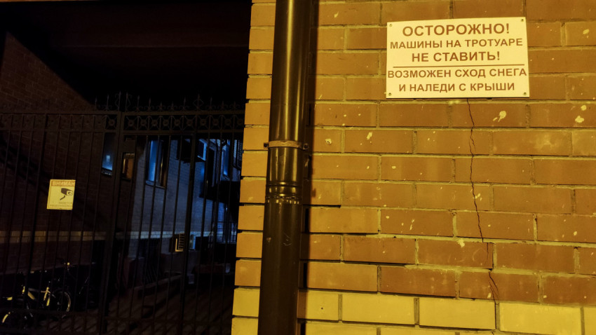 Табличка с предупреждением о сходе снега и наледи на стене дома