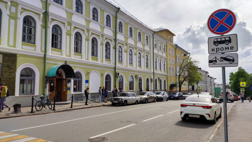 Запрещающая парковку зона возле здания с зелёным фасадом