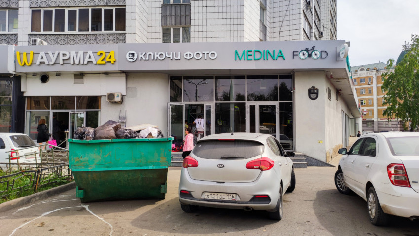 Парковка у фасада здания с кафе и фотосалоном