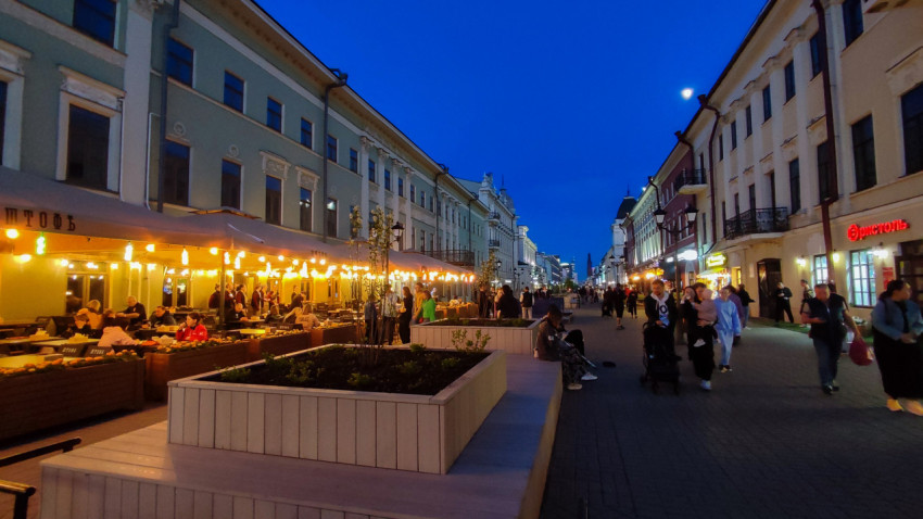 Пешеходная улица с вечерней подсветкой и уличным кафе в Казани