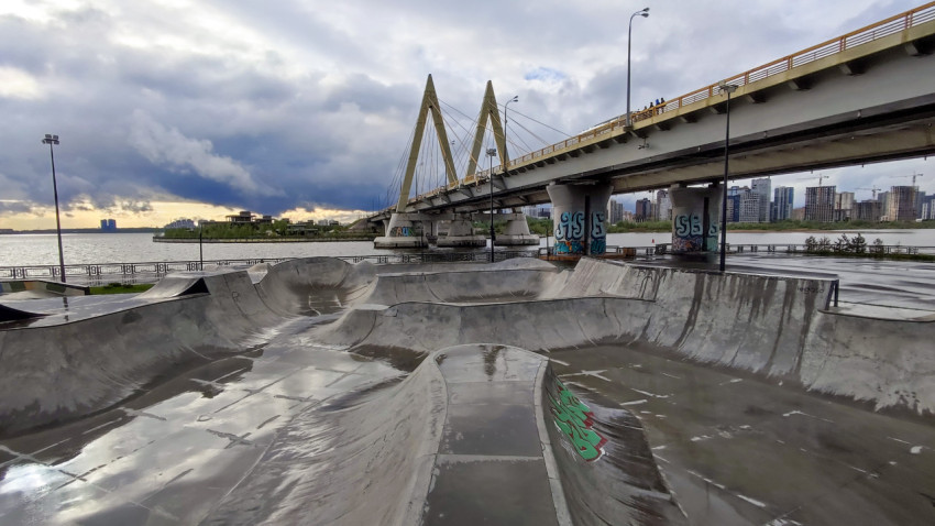 Городской мост и скейтпарк на фоне многоэтажной застройки
