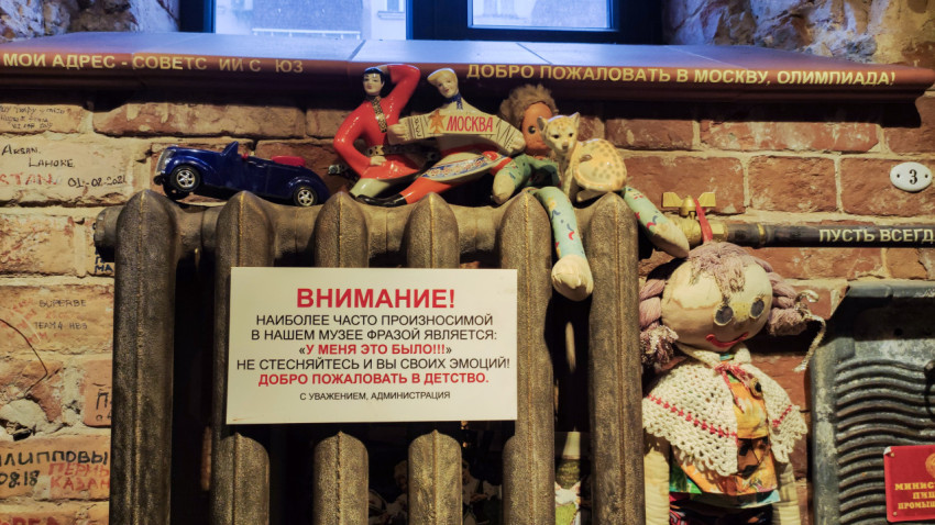 Советские игрушки и табличка на фоне кирпичной стены