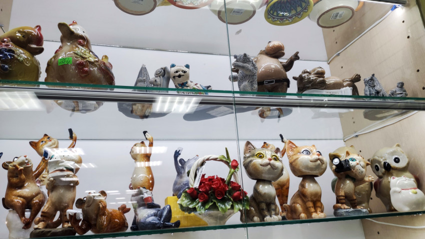 Керамические фигурки животных и корзина с розами на полке
